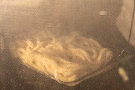 冷凍うどんは電子レンジで加熱する。加熱時間はメーカーの表記に合わせる。